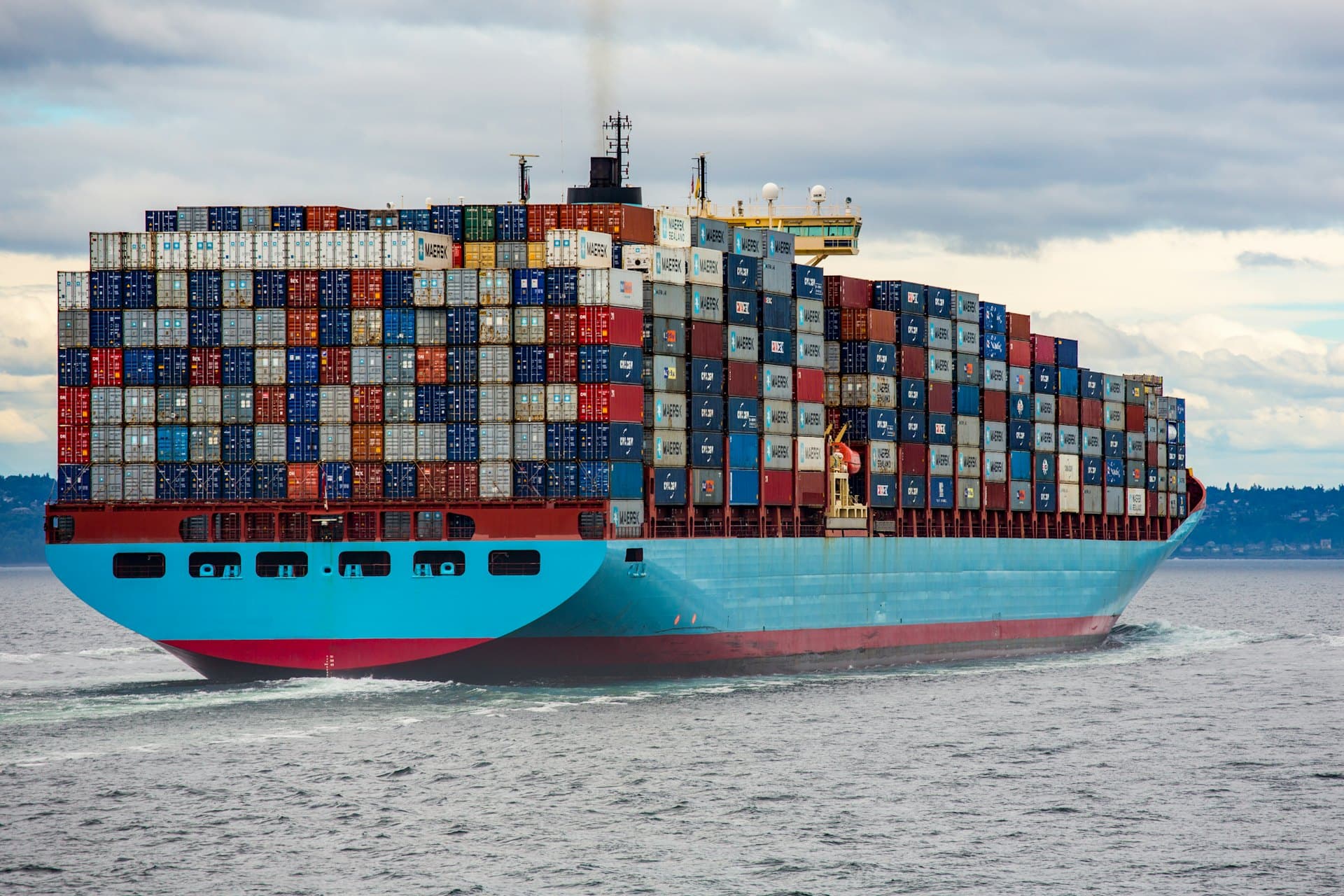 Container vessel underway at sea, fully loaded with shipping containers